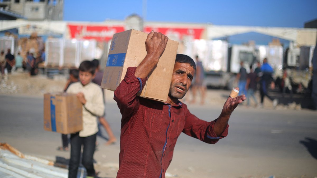 Displaced Palestinians carry boxes of food supplies that entered Gaza in the morning after receiving it from an aid distribution point at the Nuseirat refugee camp in the central Gaza Strip, Palestine, Oct. 20, 2025. (AFP Photo)