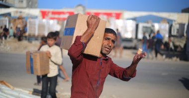 Displaced Palestinians carry boxes of food supplies that entered Gaza in the morning after receiving it from an aid distribution point at the Nuseirat refugee camp in the central Gaza Strip, Palestine, Oct. 20, 2025. (AFP Photo)