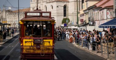 Tourists take pictures as the historical trams of Carris (Lisbon’s public transport) take part in the annual parade of classical trams and buses in celebration of the 152nd anniversary of the company, Lisbon, Portugal, Sept. 21, 2024. (AFP File Photo)