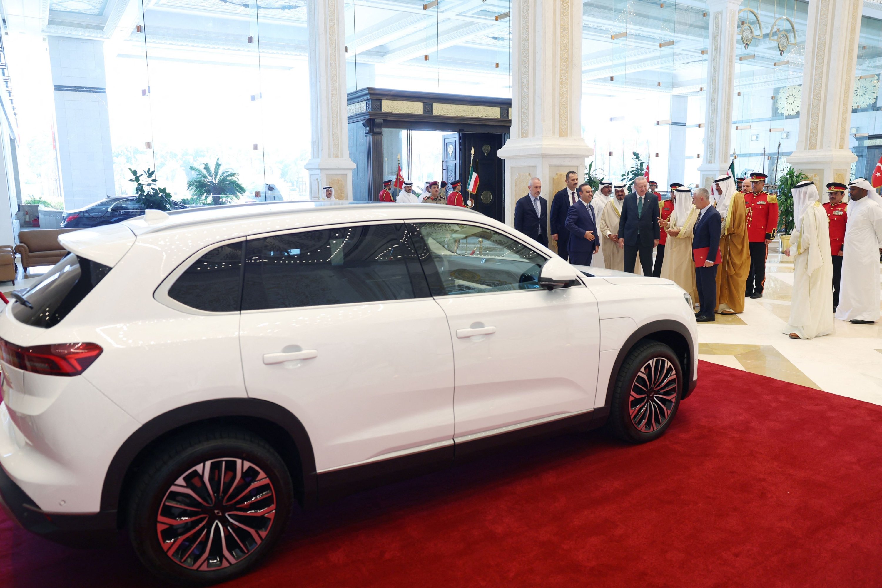 This handout photograph shows President Recep Tayyip Erdoğan (C-L) presenting the Turkish-made Togg electric car to Kuwait's Emir Sheikh Mishal Al Ahmad Al Sabah (C-R) in Kuwait City, during his official visit to Kuwait, Oct. 21, 2025. ( AFP Photo via Turkish Presidency Press Office)