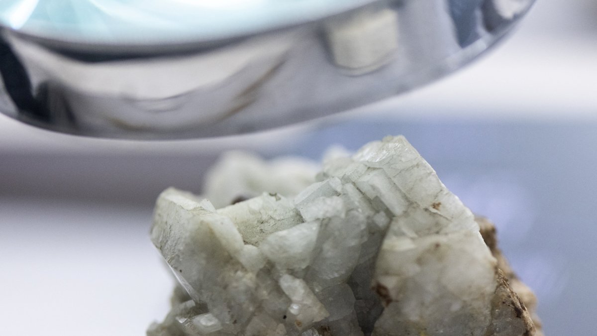 A sample of monazite, a mineral used in the rare earth industry to extract elements such as cerium, lanthanum, and neodymium, is displayed next to a magnification glass at the Geological Museum of China in Beijing, China, Oct. 14, 2025. (Reuters Photo)