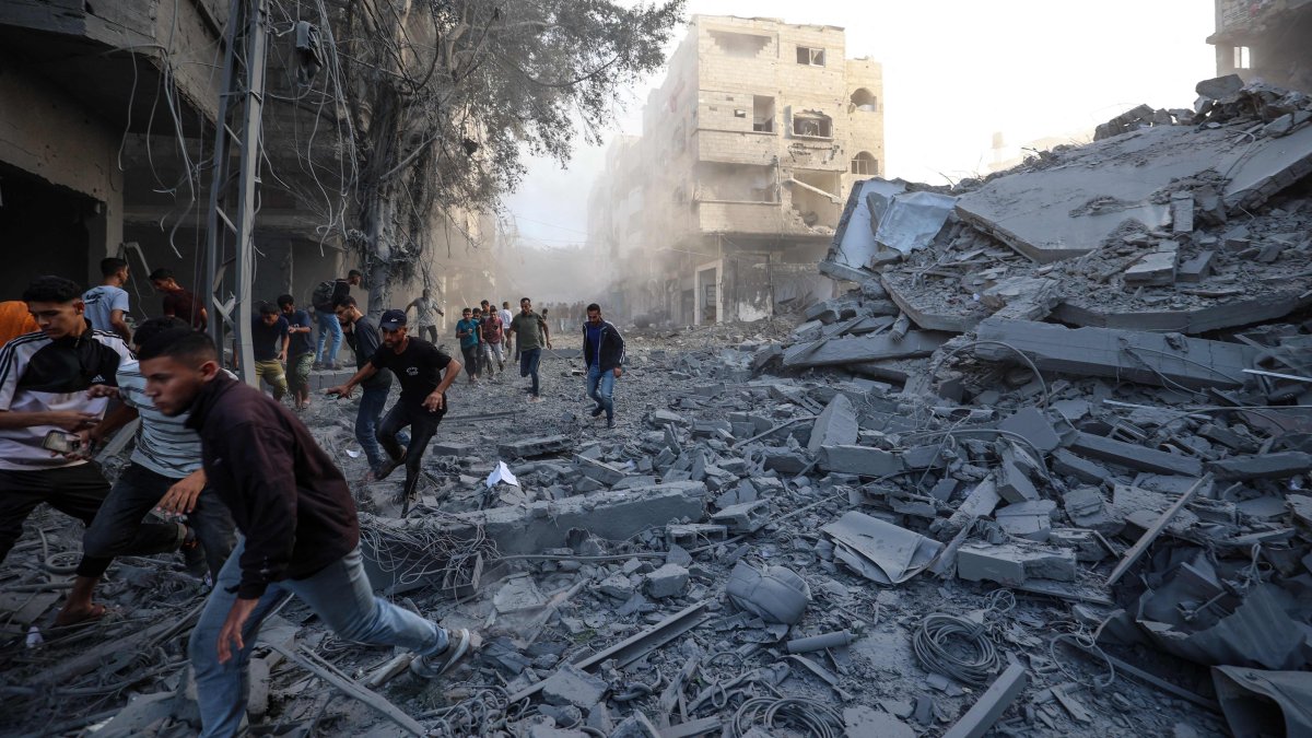 People run for cover following an Israeli strike that targeted a building in the Bureij camp in the central Gaza Strip, Palestine, Oct. 19, 2025. (AFP Photo)