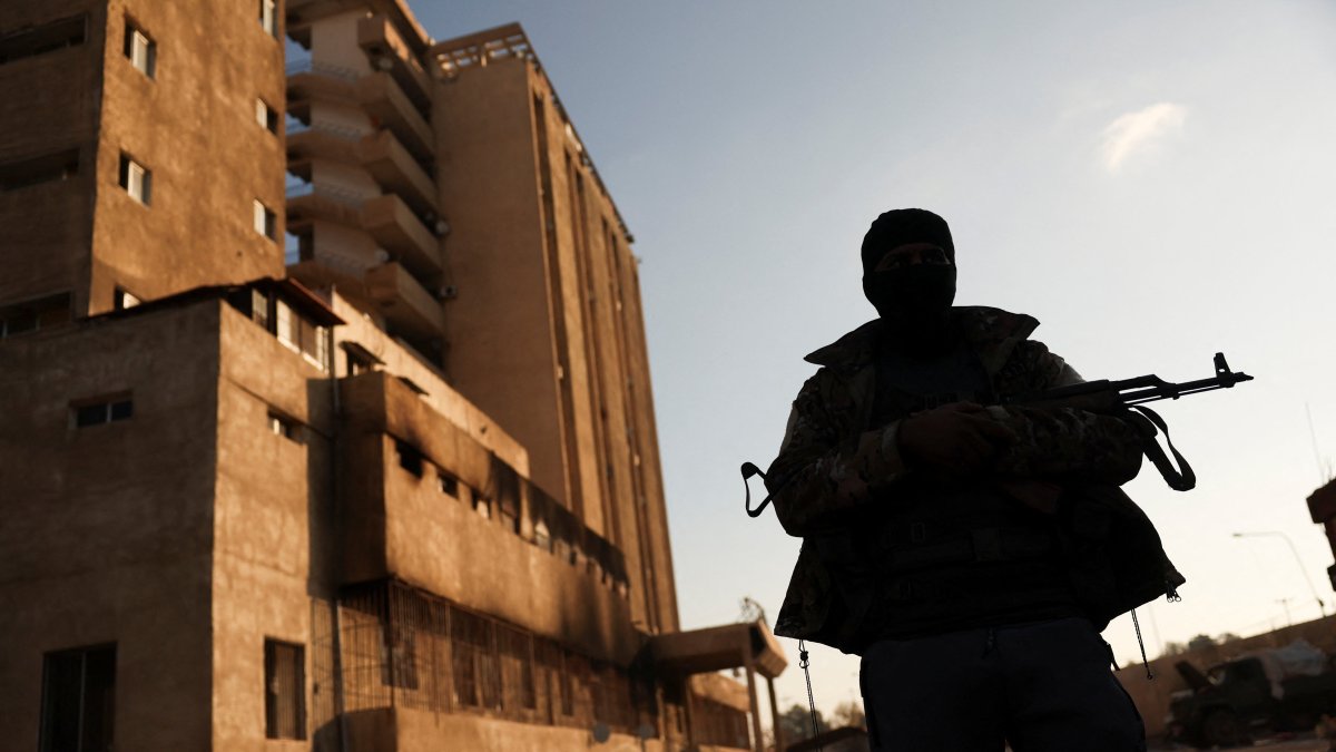 A fighter with Hayat Tahrir al-Sham (HTS) stands outside the Palestine Branch security complex in Damascus, Syria, Dec.13, 2024. (Reuters File Photo)