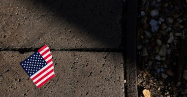 A torn American flag sticker lies on the ground, Washington, D.C., U.S., Oct. 20, 2025. (Reuters Photo)