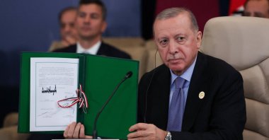 President Recep Tayyip Erdoğan poses with the signed agreement at a world leaders&#039; summit on ending the Gaza war, Sharm el-Sheikh, Egypt, Oct. 13, 2025. (Reuters Photo)