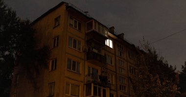 A lone window is lit in an apartment building in a neighborhood that experiences power cuts following Russian drone and missile strikes, Kyiv, Ukraine, Oct. 10, 2025. (Reuters Photo)