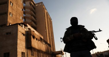 A fighter with Hayat Tahrir al-Sham (HTS) stands outside the Palestine Branch security complex in Damascus, Syria, Dec.13, 2024. (Reuters File Photo)
