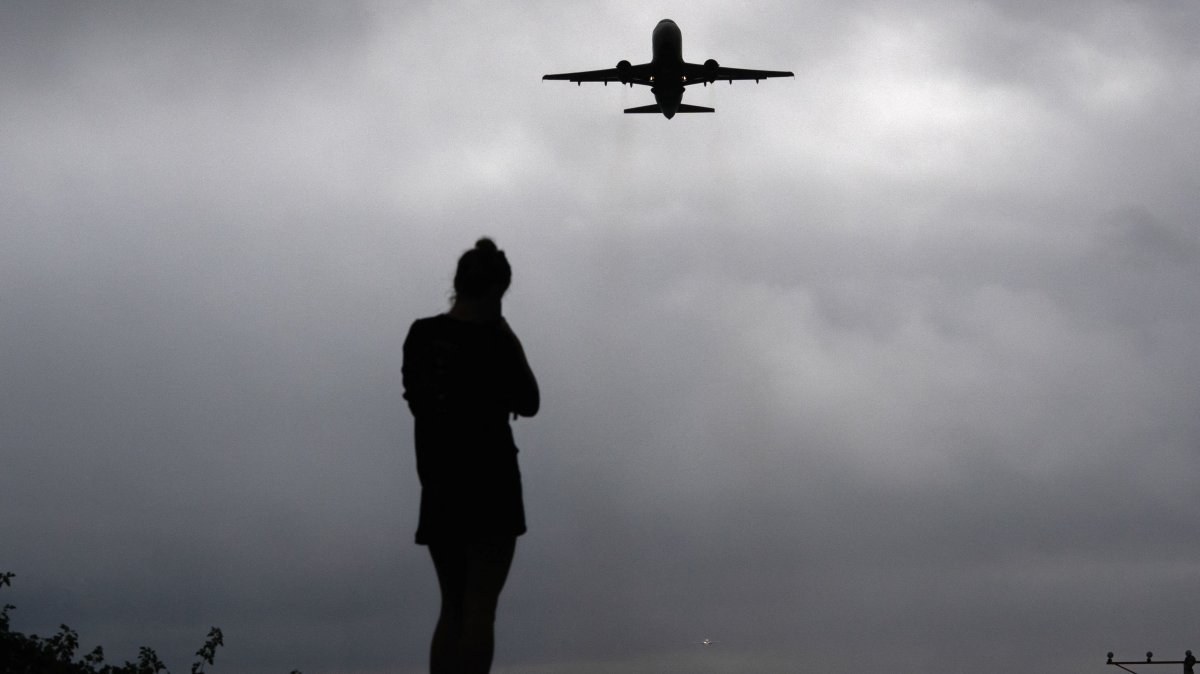 A runner watches as a plane takes off from Reagan Washington National Airport, Arlington, Virginia, U.S., Oct. 8, 2025. (Reuters Photo)