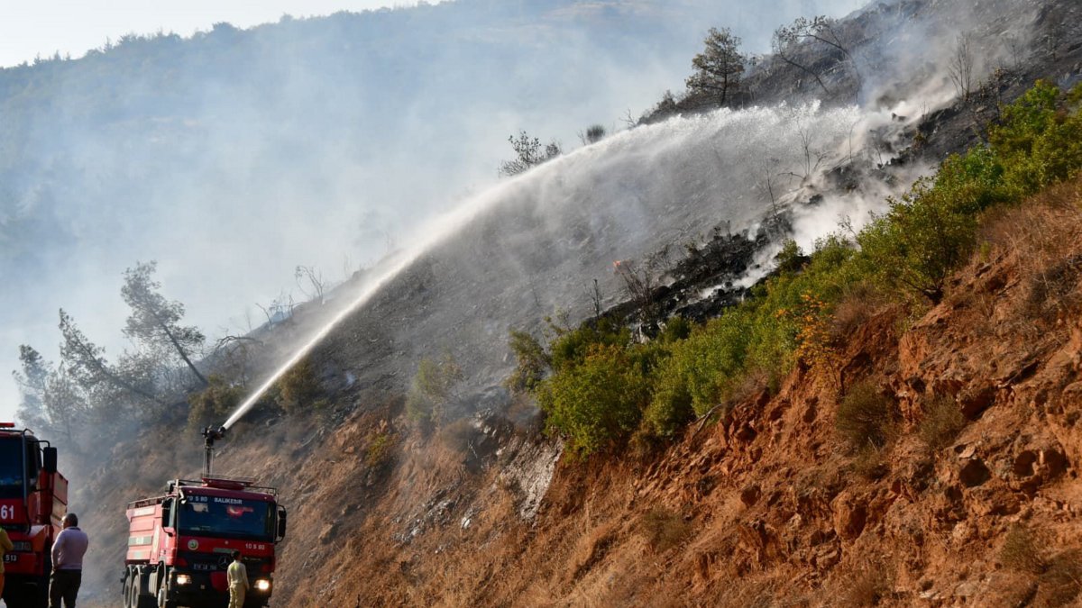 Fire spreads to a forested area after a vehicle accident as firefighting crews work from both land and air to control the blaze, Balıkesir, Türkiye, Sept. 27, 2025. (AA Photo)
