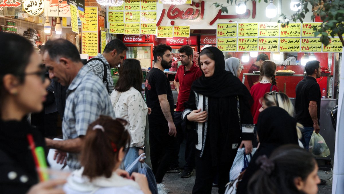Iranian people walk at the Tehran Bazaar after the approval of the bill to remove four zeros from the national currency, in Tehran, Iran, Oct. 5, 2025. (WANA via Reuters)