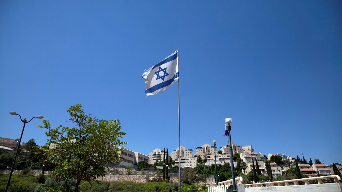 The Israeli national flag flutters as apartments are seen in the background in the Israeli settlement of Maale Adumim in the Israeli-occupied West Bank, Aug. 16, 2020. (Reuters Photo)