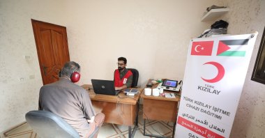 A Turkish Red Crescent (Kızılay) team member assists a patient with a hearing aid, Gaza, Palestine, Oct. 22, 2025. (AA Photo)