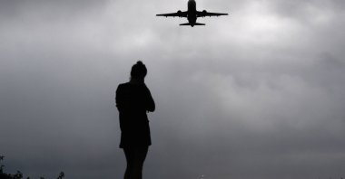 A runner watches as a plane takes off from Reagan Washington National Airport, Arlington, Virginia, U.S., Oct. 8, 2025. (Reuters Photo)