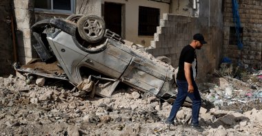 A Palestinian walks near a damaged vehicle, after an Israeli raid in Tubas, in the occupied West Bank, Oct. 19, 2025. (Reuters Photo)