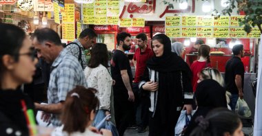 Iranian people walk at the Tehran Bazaar after the approval of the bill to remove four zeros from the national currency, in Tehran, Iran, Oct. 5, 2025. (WANA via Reuters)