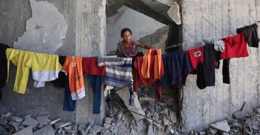 A Palestinian girl hangs clothes to dry inside the Imam al Shafi’i Mosque, where families have taken shelter, in the Zeitoun neighbourhood of Gaza City, Palestine, Oct. 23, 2025. (AFP Photo)