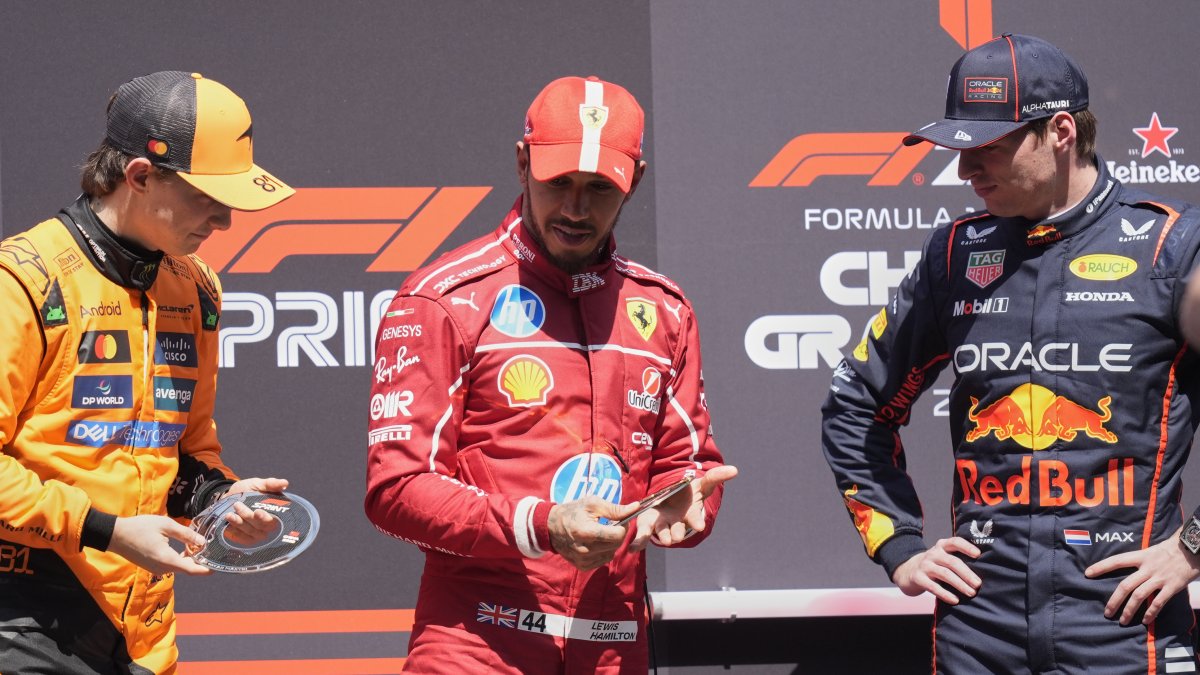 Ferrari driver Lewis Hamilton is flanked on the podium with McLaren driver Oscar Piastri (L) and Red Bull driver Max Verstappen after the sprint race ahead of the Chinese Formula One Grand Prix at the Shanghai International Circuit, Shanghai, China, March 22, 2025. (AP Photo)