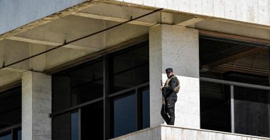 A member of the Syrian authorities&#039; new security forces stands guard outside a polling station where members of Syrian local committees have been casting their votes, Damascus, Syria, Oct. 5, 2025. (AFP Photo)
