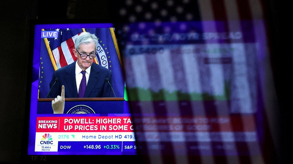 A U.S. flag hangs in front of a screen that broadcasts a news conference by U.S. Federal Reserve Chair Jerome Powell following the Fed rate announcement, on the floor of the New York Stock Exchange (NYSE) in New York City, U.S., Sept. 17, 2025. (Reuters Photo)