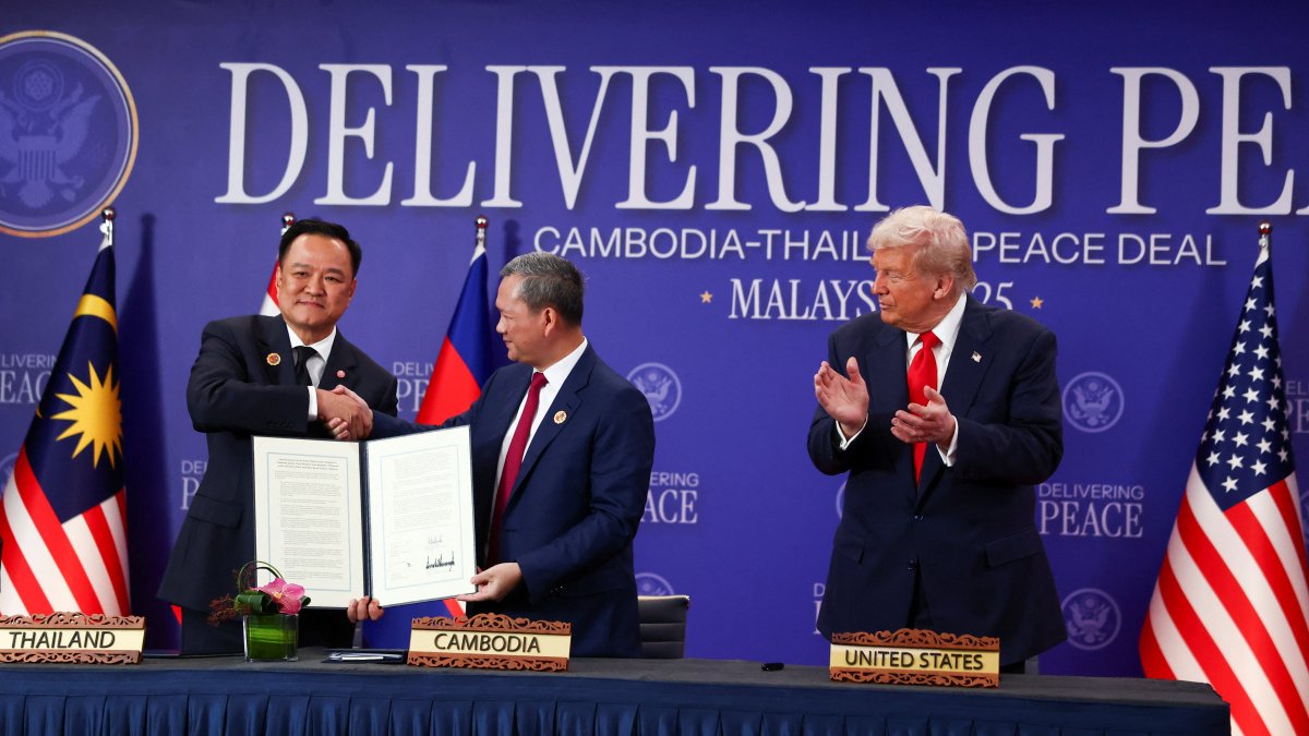 Thailand&#039;s Prime Minister Anutin Charnvirakul (L) and Cambodia’s Prime Minister Hun Manet shake hands and hold up a cease-fire document, while U.S. President Donald Trump applauds, in Kuala Lumpur, Malaysia, Oct. 26, 2025. (Reuters Photo)