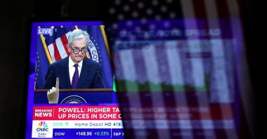 A U.S. flag hangs in front of a screen that broadcasts a news conference by U.S. Federal Reserve Chair Jerome Powell following the Fed rate announcement, on the floor of the New York Stock Exchange (NYSE) in New York City, U.S., Sept. 17, 2025. (Reuters Photo)