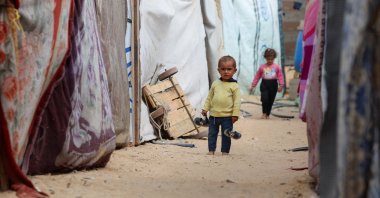 A child stands between tents for war-displaced Palestinians, who fled northern Gaza due to an Israeli genocidal war, in the central Gaza Strip, Oct. 6, 2025. (Reuters Photo)