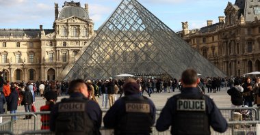 Police officers stand guard near the Louvre Pyramid, after French police arrested suspects in the Louvre heist case, at the Louvre Museum in Paris, France, Oct. 26, 2025. (Reuters Photo)