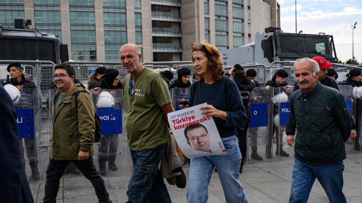 Protesters walk past Turkish police securing the area in front of the Istanbul Courthouse during a rally organized by the country&#039;s main opposition party, the Republican People&#039;s Party (CHP), to protest the suspension and imprisonment of disgraced Istanbul Mayor Ekrem Imamoğlu, Istanbul, Oct. 26, 2025. (AFP Photo)