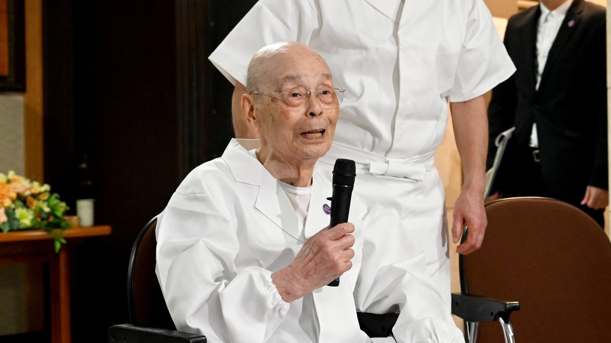 Sushi legend Jiro Ono talks to reporters, who gathered in front of his restaurant to celebrate his 100th birthday, Tokyo, Japan, Sept. 18, 2025. (AP Photo)