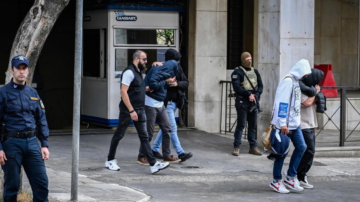 Arrested suspects, allegedly "involved in large-scale agricultural funding fraud and money laundering" according to the European public prosecutor's office (EPPO), are escorted by plainclothes police officers, Athens, Greece, Oct. 23, 2025. (AFP Photo)