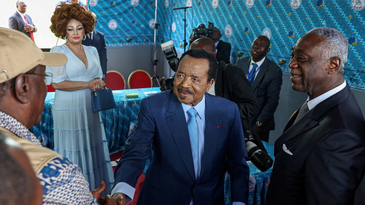 Cameroonian President Paul Biya, 92, shakes hands with an election observer after casting his ballot while his wife Chantal looks on, during the presidential election, Yaounde, Cameroon, Oct. 12, 2025. (REUTERS Photo)
