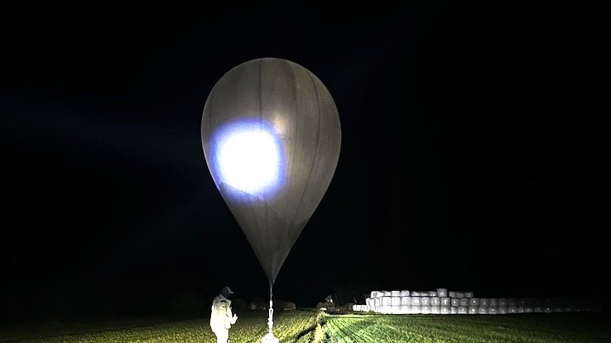 In this undated photo released by the State Border Guard Service, an officer inspects a balloon used to carry cigarettes into Lithuania, because Belarussian smugglers often use them to ferry the contraband into the European Union (AP Photo)