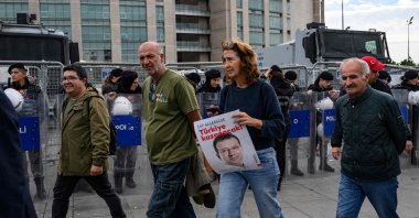 Protesters walk past Turkish police securing the area in front of the Istanbul Courthouse during a rally organized by the country&#039;s main opposition party, the Republican People&#039;s Party (CHP), to protest the suspension and imprisonment of disgraced Istanbul Mayor Ekrem Imamoğlu, Istanbul, Oct. 26, 2025. (AFP Photo)