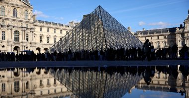 People stand outside the Louvre Museum, after French police arrested suspects in the Louvre heist case, Paris, France, Oct. 26, 2025. (Reuters Photo)