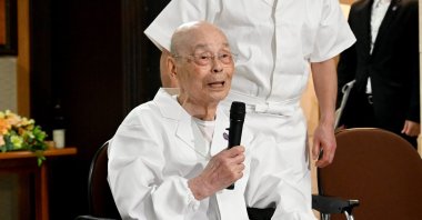 Sushi legend Jiro Ono talks to reporters, who gathered in front of his restaurant to celebrate his 100th birthday, Tokyo, Japan, Sept. 18, 2025. (AP Photo)