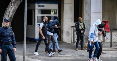 Arrested suspects, allegedly &quot;involved in large-scale agricultural funding fraud and money laundering&quot; according to the European public prosecutor&#039;s office (EPPO), are escorted by plainclothes police officers, Athens, Greece, Oct. 23, 2025. (AFP Photo)