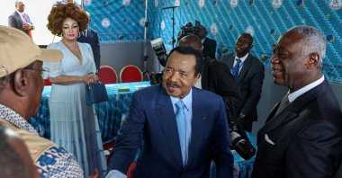 Cameroonian President Paul Biya, 92, shakes hands with an election observer after casting his ballot while his wife Chantal looks on, during the presidential election, Yaounde, Cameroon, Oct. 12, 2025. (REUTERS Photo)