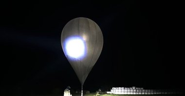 In this undated photo released by the State Border Guard Service, an officer inspects a balloon used to carry cigarettes into Lithuania, because Belarussian smugglers often use them to ferry the contraband into the European Union (AP Photo)