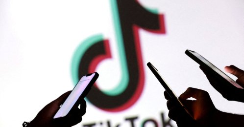 People holding smartphones in front of a TikTok logo in this illustration taken Sept. 11, 2025. (Reuters Photo)