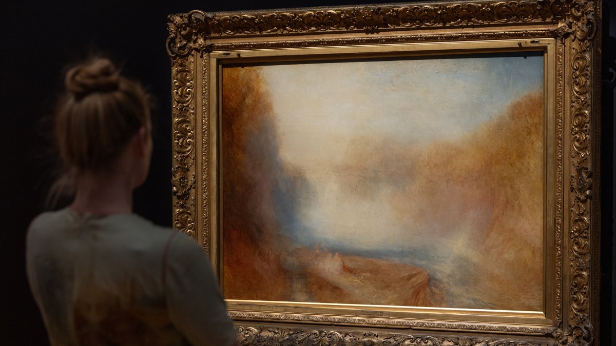 Curator of British Art Dr. Melissa Gustin poses with "The Falls of the Clyde" by JMW Turner during a press preview for "Turner: Always Contemporary" at the Walker Art Gallery, Liverpool, U.K., Oct. 23, 2025. (EPA Photo)