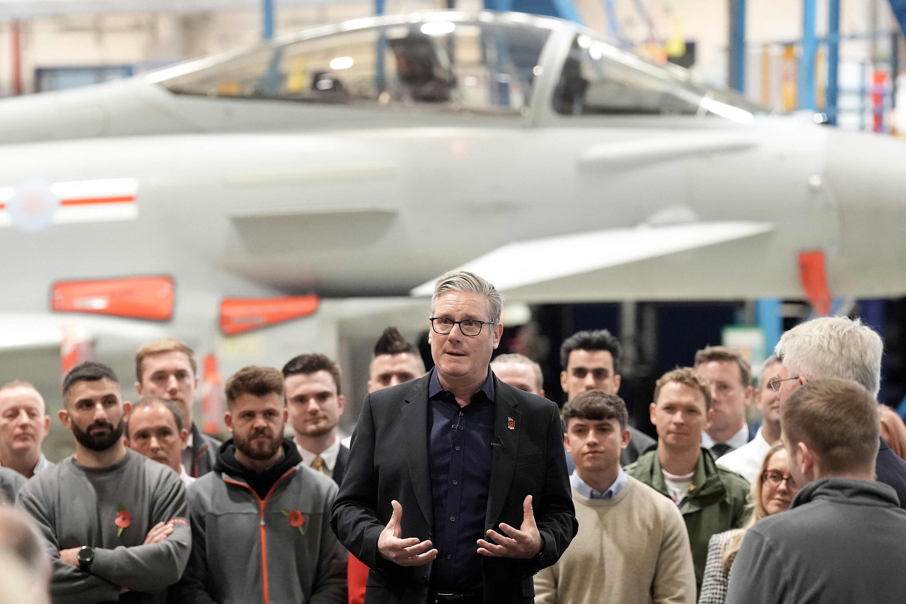British Prime Minister Keir Starmer stands in front of a Eurofighter Typhoon fighter jet as he talks to workers during a visit to BAE Systems, Warton, U.K., Oct. 28, 2025. (AFP Photo)