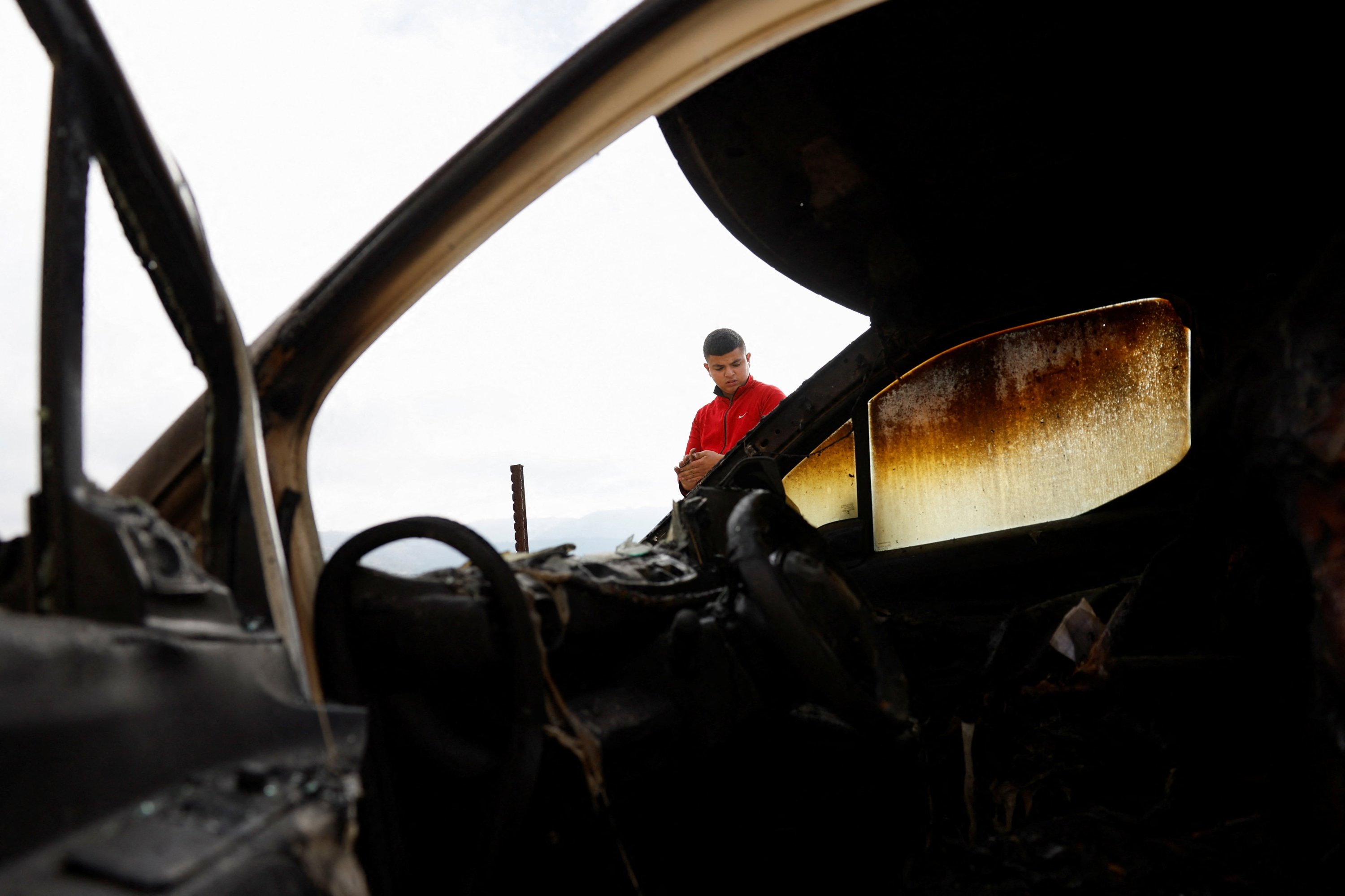A Palestinian man stands near a car that was burned by Israeli settlers in the Palestinian village of Atara, near Ramallah, Israeli-Occupied West Bank, Oct. 29, 2025. (Reuters Photo)