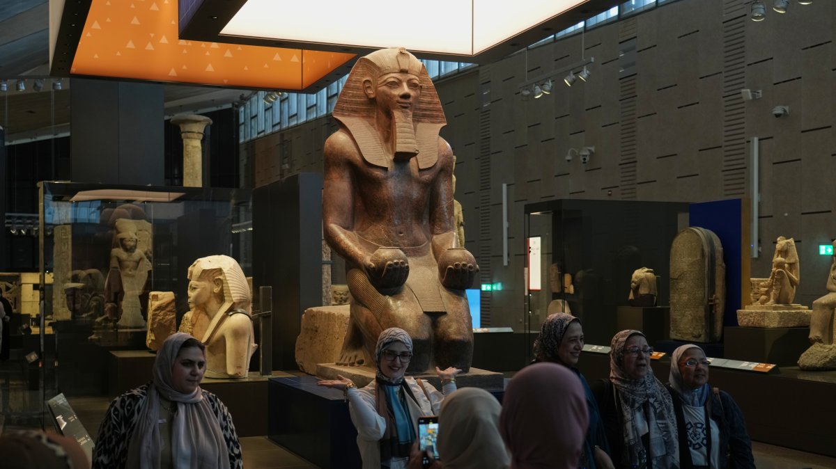 Visitors pose for a group photo under the Hatshepsut statue, at the Grand Egyptian Museum, Giza, Egypt, May 23, 2025. (AP Photo)
