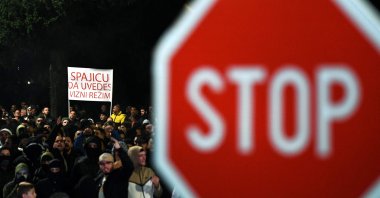 A demonstrator holds a placard reading &quot;Introduce a Visa Regime&quot; during a protest in the capital, Podgorica, Montenegro, Oct. 28, 2025. (AFP Photo)