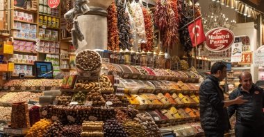 People chat next to a dried fruit and spices shop at the Istanbul Spice Bazaar, Istanbul, Türkiye, Jan. 8, 2025. (Shutterstock Photo)