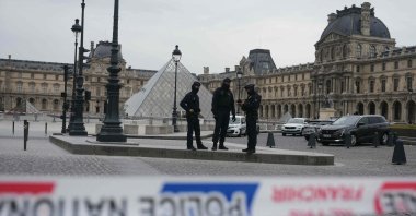 French police officers patrol in front of the Louvre Museum after it was robbed, with the Louvre Pyramid designed by Ieoh Ming Pei in the background, Paris, France, Oct. 19, 2025. (AFP Photo)