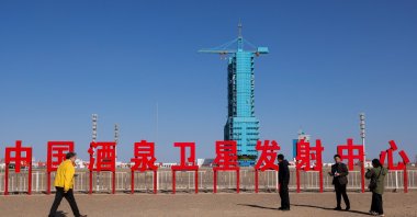 Journalists and officials gather as the launch pad for the Long March-2F rocket stands behind Chinese characters reading &quot;China Jiuquan Satellite Launch Center,&quot; ahead of the Shenzhou-21 spaceflight mission to China&#039;s Tiangong space station, at the Jiuquan Satellite Launch Center, near Jiuquan, Gansu province, China, Oct. 30, 2025. (Reuters Photo(