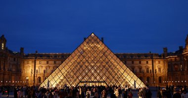 People walk near the glass Pyramid of the Louvre Museum as French police arrested more suspects linked to the theft of treasures from the museum&#039;s Galerie d&#039;Apollon, Paris, France, Oct. 30, 2025. (Reuters Photo)