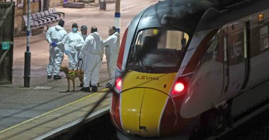 Forensic investigators on the platform by a train at Huntingdon station after a mass stabbing on a London-bound train in eastern England, in Cambridgeshire, England, Nov. 1, 2025. (AP Photo)