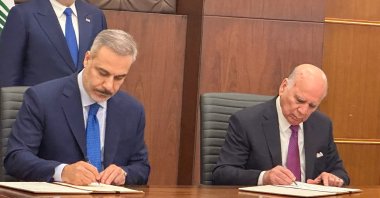 Foreign Ministers Hakan Fidan (L) and Fuad Hussein of Iraq (R) sign the document as Iraqi Prime Minister Mohammed Shia Al Sudani watches, Baghdad, Türkiye, Nov. 2, 2025. (AA Photo)